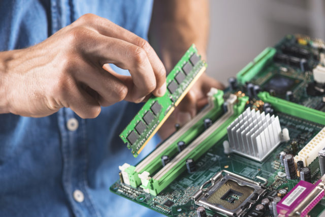 Old computer memory stick RAM man holding computer memory stick (RAM-random access memory)